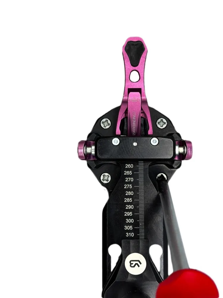 SkiClicker® Tech clicked into an ATK binding, with a screwdriver reaching the toepiece screws